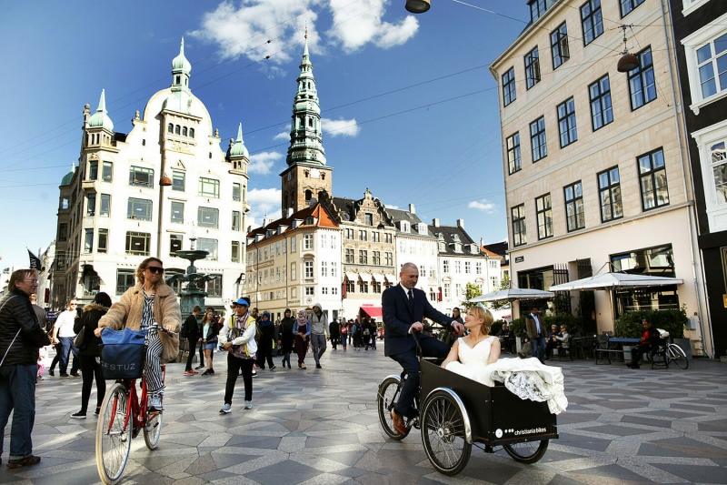 Newlyweds driving in a cargobike in the streets of Copenhagen.