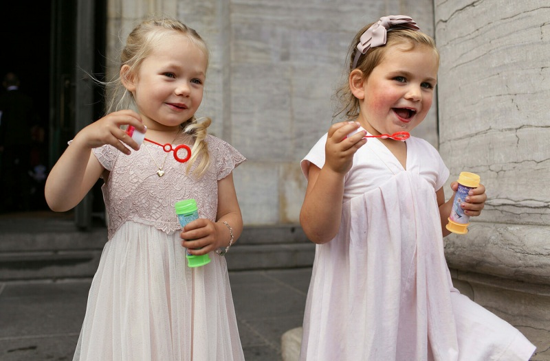Two little bridesmaids in pink dresses at a church wedding in Copenhagen.